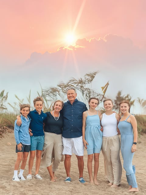 Family portrait beneath a pastel evening sky